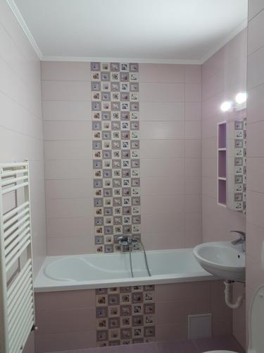 ein Badezimmer mit einer Badewanne und einem Waschbecken in der Unterkunft Blue apartament in Sibiu