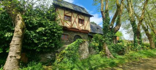 an old house with ivy growing on the side of it at Charming traditional 2-Bed Cottage near Plemet in Plémet
