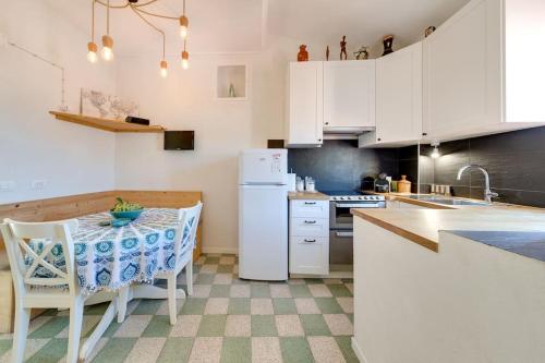 a kitchen with a table and a white refrigerator at Between the roofs of Menton old town and the sea in Menton