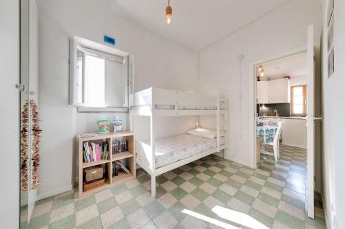a white bedroom with a bunk bed and a window at Between the roofs of Menton old town and the sea in Menton