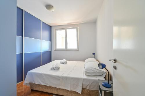 1 dormitorio con 1 cama con paredes azules y blancas en Apartment Dada Zadar -Excellent apartment nearby old city en Zadar