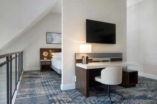 a hotel room with a desk and a bedroom at Delta Hotels by Marriott Victoria Ocean Pointe Resort in Victoria