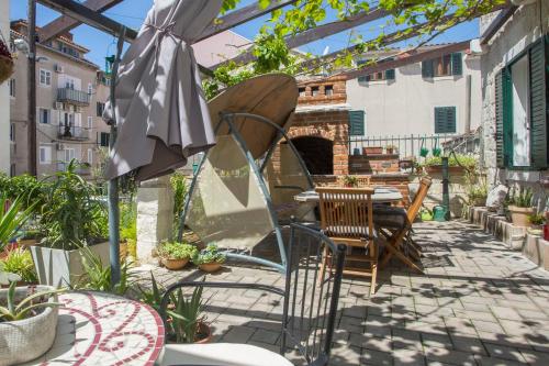 une terrasse avec une table, des chaises et un parasol dans l'établissement Bossa Studio Apartments, à Split