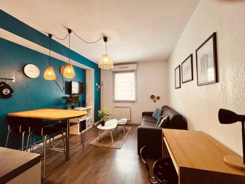 a living room with a table and a dining room at Le Jean-Jaurès / Joli studio in Nîmes