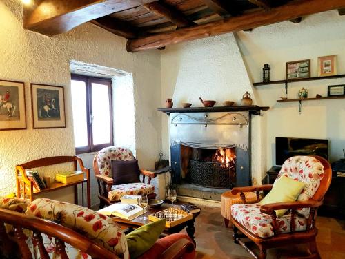 a living room with a fireplace with chairs and a table at La Baronessa Country House in Montefiascone