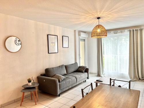 - un salon avec un canapé et une table dans l'établissement Apparthotel - Horizon Poitevin, à Poitiers