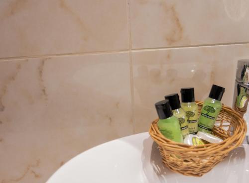 a basket of toiletries sitting on top of a bath tub at Thomas Beach Studios in Paleokastritsa