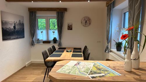 a dining room with a wooden table and chairs at Ferienwohnungen LODGE-B in Weissenbach am Lech