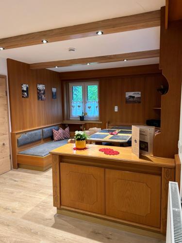 a room with a kitchen with a couch and a table at Ferienwohnungen LODGE-B in Weissenbach am Lech
