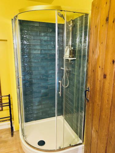 a shower with a glass door in a bathroom at Grange stables in North Cadbury
