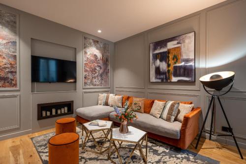 a living room with a couch and a tv at My Opéra in Paris