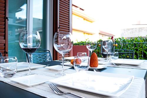 a table with wine glasses and plates on it at Villetta & Suite Angela Pozzallo 150mt mare v Auriga in Pozzallo