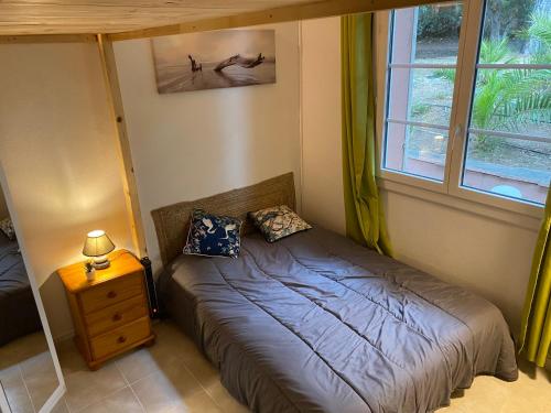 une petite chambre avec un lit et une fenêtre dans l'établissement L Annexe 50m de la plage, à Bandol