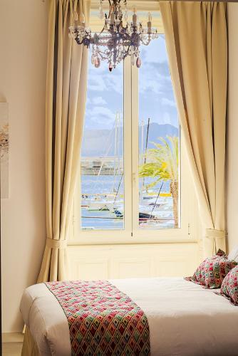 a bedroom with a window with a view of the ocean at WATERFRONT SUITES CAGLIARI in Cagliari