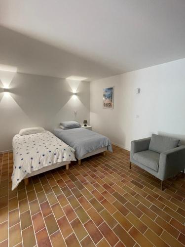 een slaapkamer met een bed, een bank en een stoel bij Petit coin de paradis in Rayol-Canadel-sur-Mer
