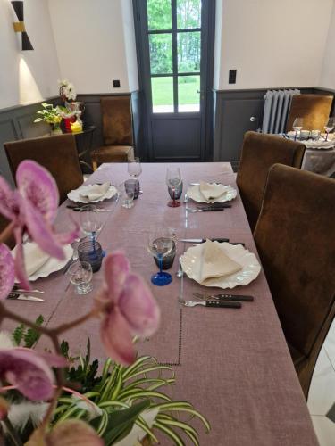 a dining room table with glasses and flowers on it at Château de Crespy & Suites 