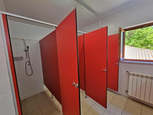 a bathroom with red doors and a shower at HI Geres - Pousada de Juventude do Gerês in Geres