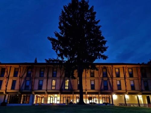 a building with a tree in front of it at HI Geres - Pousada de Juventude do Gerês in Geres