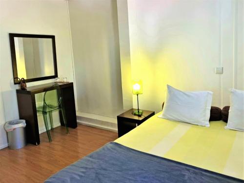 a bedroom with a bed with a mirror and a television at HI Geres - Pousada de Juventude do Gerês in Geres