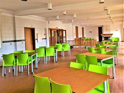 a classroom with green chairs and tables in a room at HI Geres - Pousada de Juventude do Gerês in Geres