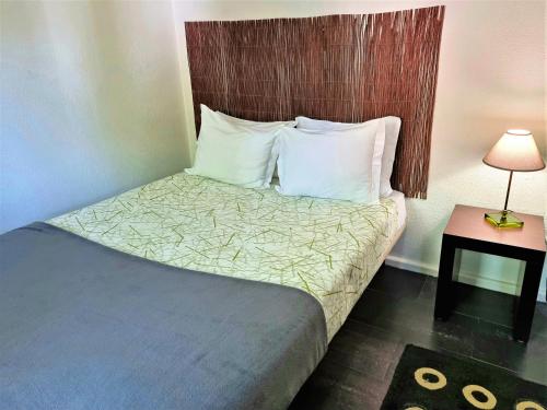a hotel room with a bed with white pillows at HI Geres - Pousada de Juventude do Gerês in Geres