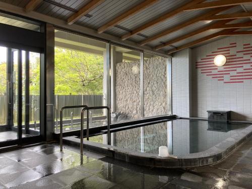 a swimming pool in a house with a glass floor at Kokumin Shukusha Marine Terrace Ashiya in Kitakyushu