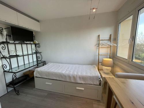 une petite chambre avec un lit et une fenêtre dans l'établissement Studio rénové 2 pers avec parking, wifi, proche plage - FR-1-224C-28, à Saint-Jean-de-Monts