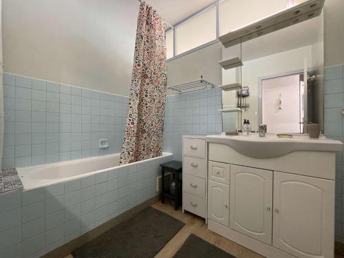 une salle de bain avec un lavabo, une baignoire et une douche dans l'établissement Appartement face mer avec balcon, 50m plage, 5 couchages, parking, Saint-Jean-de-Monts - FR-1-224C-187, à Saint-Jean-de-Monts