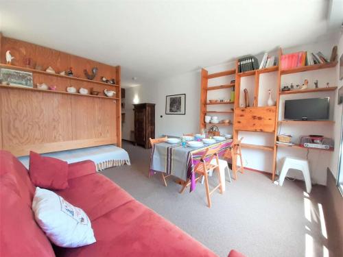 un salon avec un canapé rouge et une table dans l'établissement Studio Cabine cosy pour 6 pers. avec TV, kitchenette équipée et casier à ski à Piau-Engaly - FR-1-457-319, à Aragnouet