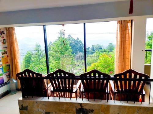 three chairs sitting in front of a large window at Awinco Haputale in Haputale