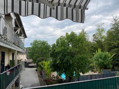 een uitzicht vanaf het balkon van een gebouw bij Logement T2 terrasse vue sur piscine in Larche