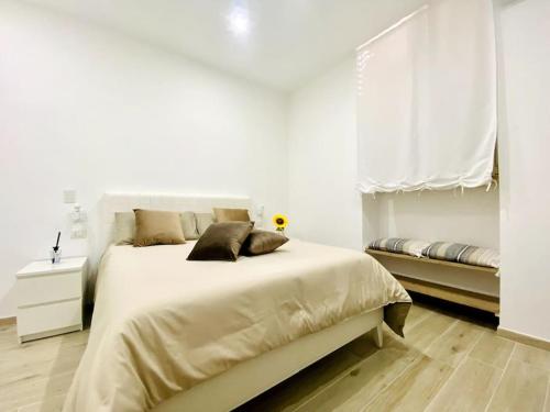 Un dormitorio blanco con una cama grande y una ventana. en Casa Carlotta - Holiday House, en Conversano