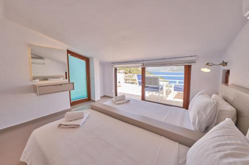 a bedroom with two beds and a large window at Villa Elmas in Kalkan