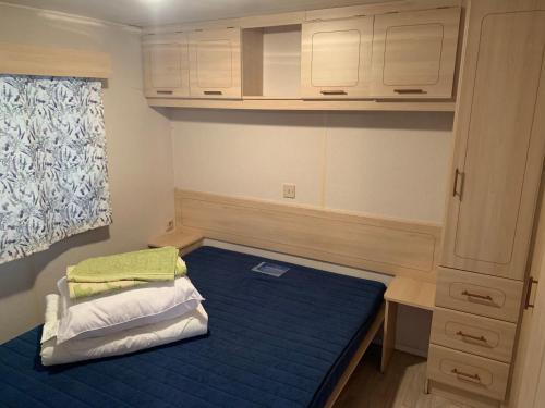 a small room with a bed and a cabinet at Lawendowa Przystań WICKO 3 km od Międzyzdrojów in Międzyzdroje