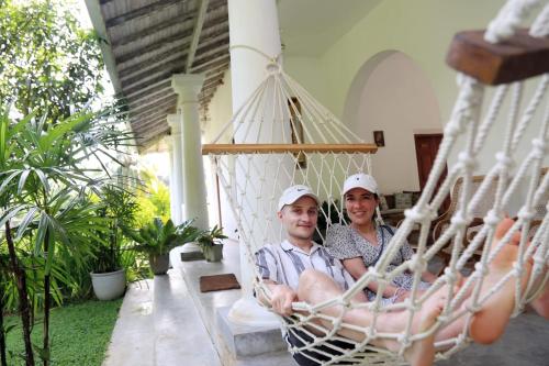 a man and a woman sitting in a hammock at Halcyon Galle in Galle