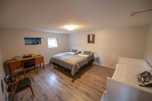sypialnia z łóżkiem i biurkiem oraz łóżko o wymiarach 6 x 6 x 6 w obiekcie Húnaver Guesthouse w mieście Blönduós