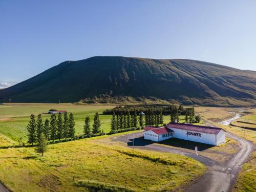 an aerial view of a farm with a mountain in the background at Húnaver Guesthouse in Blönduós