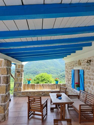 a patio with blue ceilings and a table and chairs at Etno house HAPPY VILLAGE in Cetinje