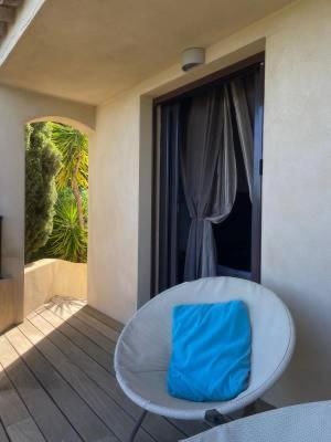 un sac bleu posé sur une chaise blanche sur un balcon dans l'établissement La chambre d'Aphrodite avec jacuzzi vue mer, à Porto-Vecchio