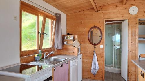 a kitchen with a sink and a window in a cabin at Les Chatcureuils in Montclar