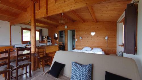 eine Blockhütte mit einem Bett und einer Küche darin in der Unterkunft Les Chatcureuils in Montclar