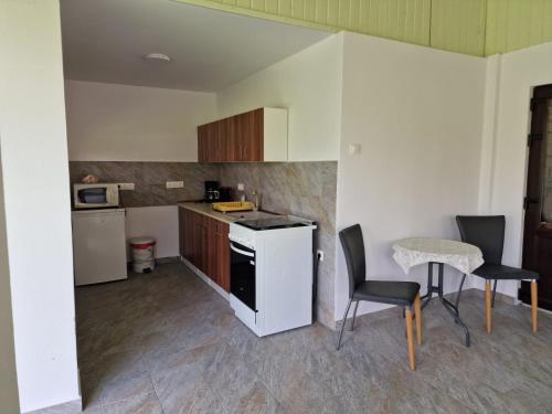 a kitchen with a stove and a table and chairs at Pensiunea Beatrice in Sovata