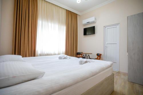een slaapkamer met een groot wit bed en een raam bij city point in Koetaisi