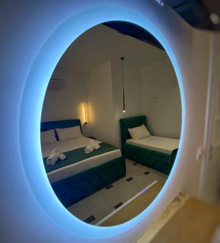 a room with two beds and a round mirror at Qeparo Napolon Complex in Qeparo