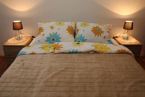 a bed with two lamps and two pillows on it at Apartman Lagodi in Križevci