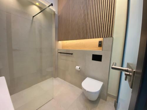a bathroom with a toilet and a glass shower at HafenCity Appartements Stralsund in Stralsund