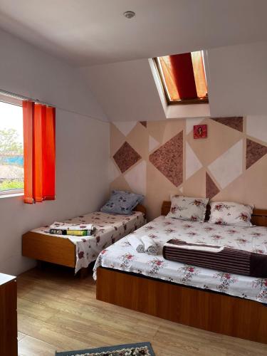 a bedroom with two beds and a window at Casa de vacanță Amy in 2 Mai