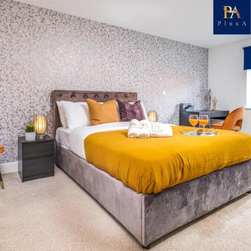 a bedroom with a large bed with a yellow blanket at Pluxa Sunstone Deluxe - Spacious Birmingham City Centre Stay in Birmingham