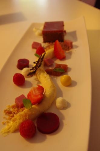 a white plate with a dessert with fruit on it at Hotel Lekker in Neumagen-Dhron