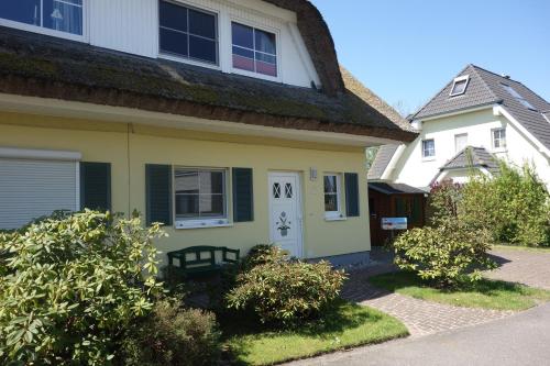 a yellow house with a white at Ferienhaus Karlin in Börgerende-Rethwisch